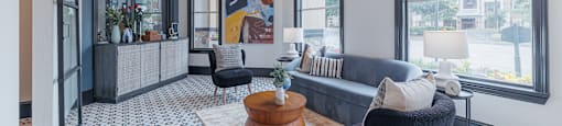A living room with a black chair and a patterned floor.