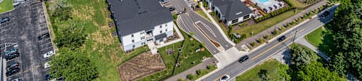 A bird's eye view of a residential area with houses, roads, and a parking lot.