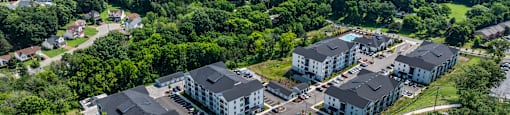 An aerial view of a large white building surrounded by trees.
