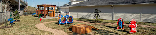 A playground with a slide, swings, and a fire hydrant.