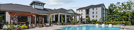 A large swimming pool with a slide and a building in the background.