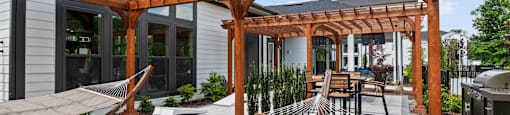 A wooden pergola over a patio with a skateboard ramp.