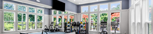 A gym with a variety of equipment including weights and exercise machines.