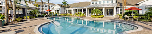 a swimming pool with palm trees in front of a building