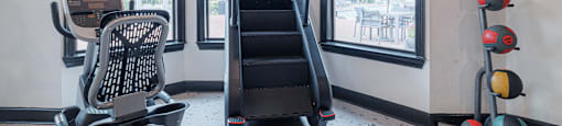 A fitness center with a treadmill, exercise balls, and a weight bench.