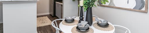 an open kitchen and dining area with a table and plants