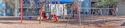 A playground with a blue canopy and red swings.