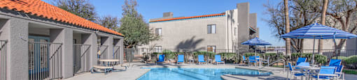 A large blue swimming pool with a red roofed building in the background.