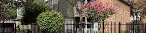 an apartment building with a black fence in front of it