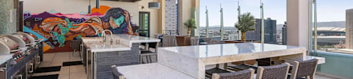 A patio with a table and chairs overlooking a cityscape.