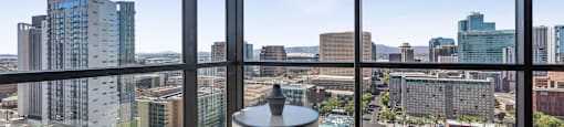 Two chairs are placed in front of a window with a city view.