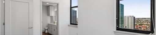 A room with a window overlooking a cityscape.