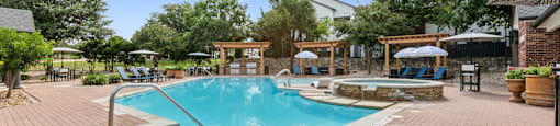 A pool surrounded by a brick patio with a blue sky in the background.