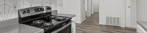 an empty kitchen with white cabinets and a black stove