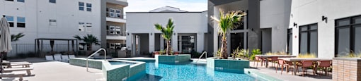 A swimming pool in a courtyard surrounded by buildings.