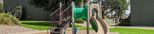 a playground with a slide and climbing equipment in a park