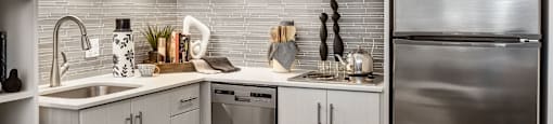 A modern kitchen with stainless steel appliances and white cabinets.