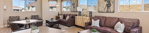 A living room with brown furniture and a ceiling fan.