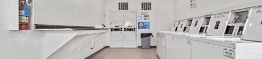 a laundry room with white appliances and a ceiling fan