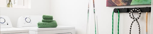 A laundry room with a basket on the floor and a washing machine to the left.