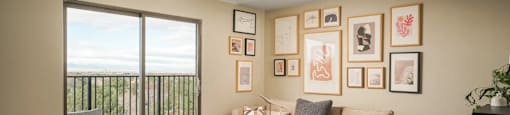 A living room with a sofa, a chair, a coffee table, and pictures on the wall.