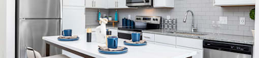 a kitchen with stainless steel appliances and a table with chairs