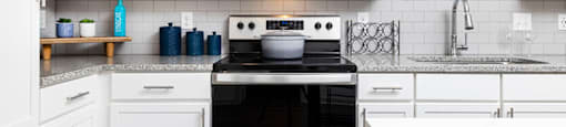 a white kitchen with a stove and a microwave