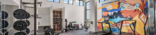 A gym with a variety of equipment including weights, a treadmill, and a stationary bike.