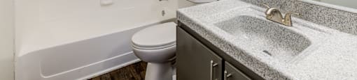 A bathroom with a toilet, sink, and shower.