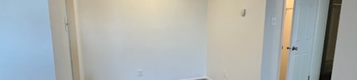 an empty living room with carpeting and white walls
