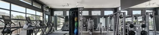 the gym has plenty of equipment and windows to the outdoors