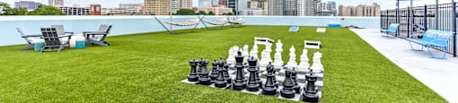 A giant chess set is set up on a lawn.