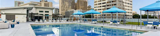 A large swimming pool with a city skyline in the background.