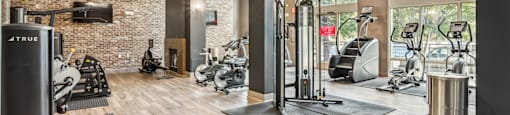 A gym with a brick wall and wooden floors.