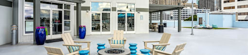 A white building with a patio area and chairs.