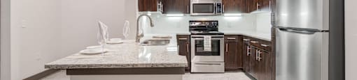 a kitchen with stainless steel appliances and a marble counter top