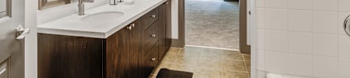 a bathroom with a sink and a mirror and a door to a shower
