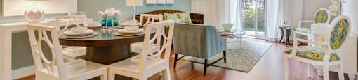 a living room with a dining room table and chairs and a ceiling fan