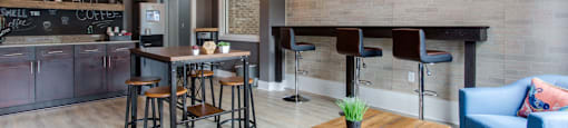a living room with a bar and a dining area with chairs and tables