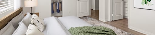 A bedroom with a large bed and a green blanket.