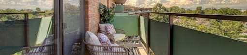 A balcony with a person sitting on a chair.