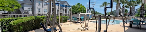 A gym with exercise equipment and a pool in the background.
