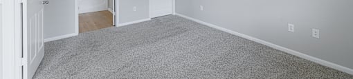 A room with a ceiling fan and carpeted floor.