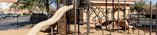 Rapallo Apartments community playground equipped with slide and jungle gym.