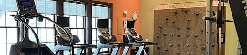 Fitness center with rotating climbing wall