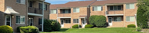 Apartment complex with green lawn in front.