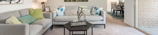 A living room with a grey couch and a coffee table.