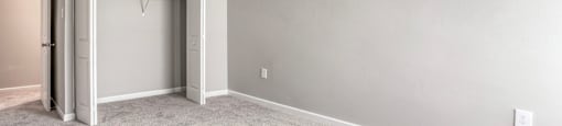 A room with a grey carpet and a white door.
