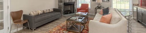 A living room with a grey couch, a chair, a coffee table, and a fireplace.
