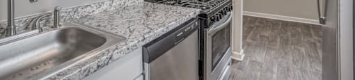 A kitchen with a sink, stove, and refrigerator.
